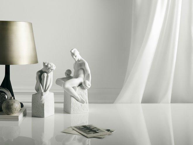 Minimalistisk borddekoration med hvide skulpturer, lampe og elegante detaljer i skandinavisk stil.