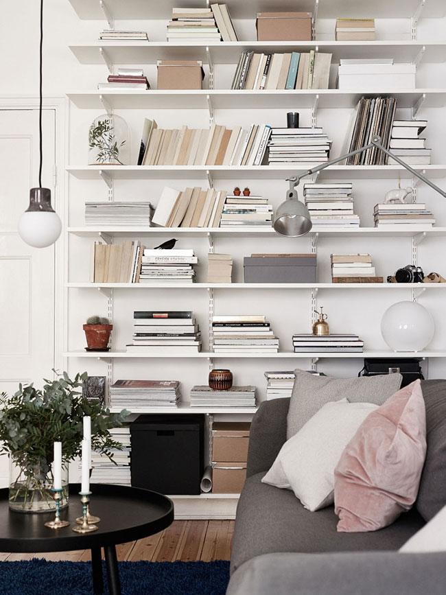 Indbygget vægreol med åbne hylder og dekorative genstande i moderne boligindretning.