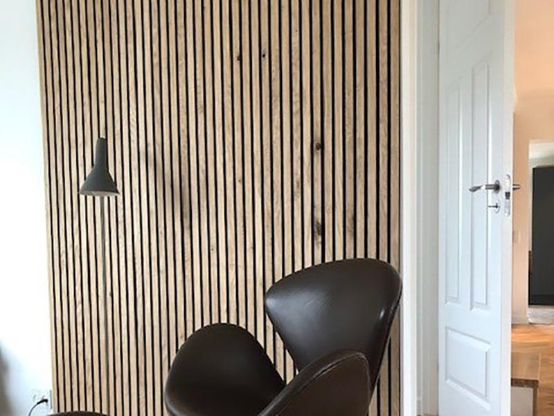 Dekorative trælameller på væg som moderne akustikpanel i skandinavisk boligindretning.